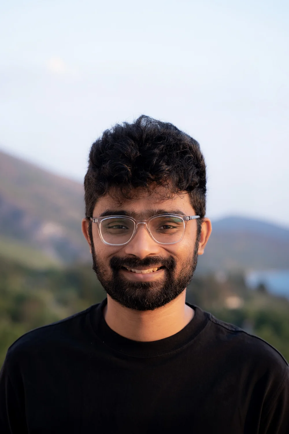 Anas smiling outdoors in the afternoon light